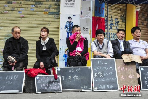 资料图：2015年3月17日，广州海珠区康乐村，小制衣厂的老板和管理人员拿着简易的招工牌在路边招工。<a target='_blank' href='http://www.chinanews.com/'>中新社</a>发 陈骥旻 摄