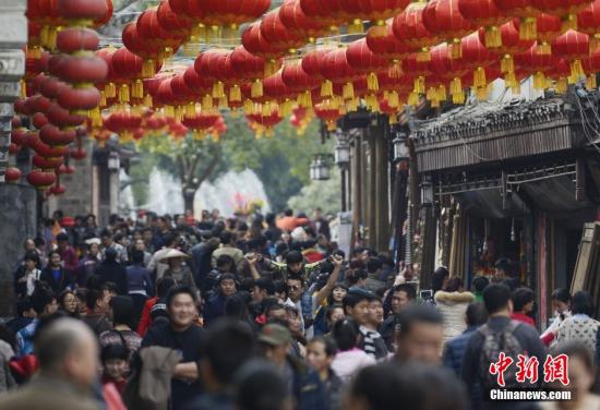 资料图：猴年春节期间，数万游客涌入湖南凤凰古城欢度春节，景区到处是游人如织的火爆场面。 杨华峰 摄